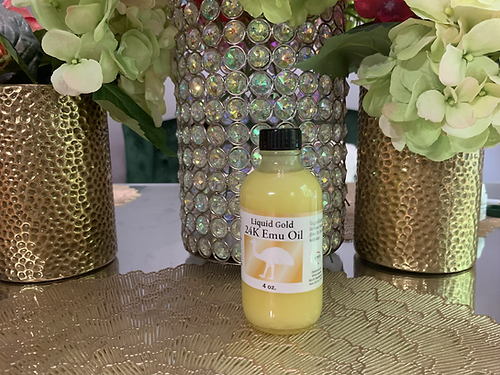 Bottle of 24K emu oil for hair growth placed on a decorative table between floral arrangements