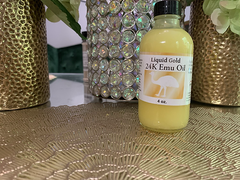 Bottle of Liquid Gold 24K emu oil for hair growth placed on decorative gold surface