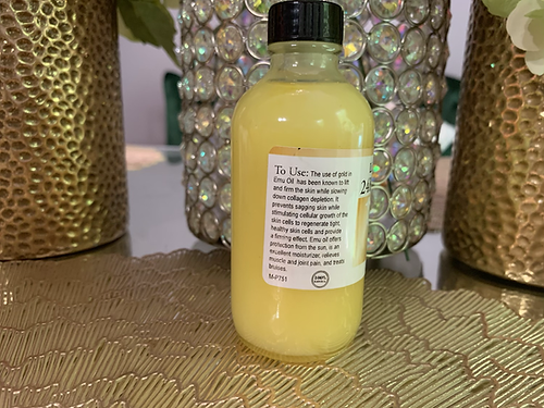 Clear bottle of 24K emu oil for hair growth with black cap and product instructions label