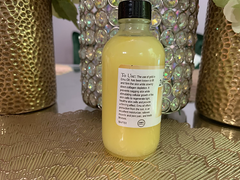 Clear bottle of 24K emu oil for hair growth with black cap and product instructions label