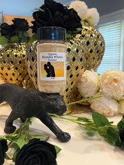 Organic mondia whitei powder container displayed on a black panther figurine with decorative flowers and golden vases