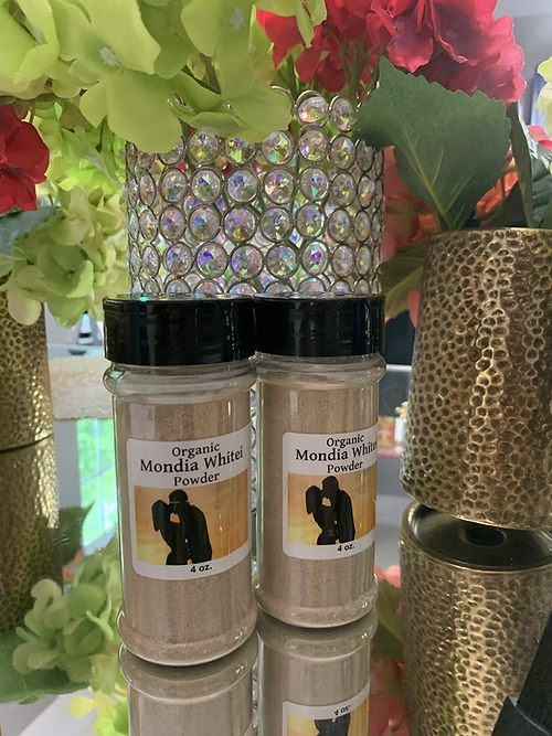 Two 4 oz jars of organic mondia whitei powder with black lids on a reflective surface with decorative flowers